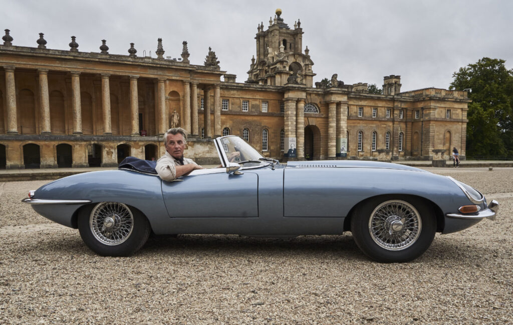 Model dressed in Neem clothes, sitting in an electric E-Type Jaguar converted by Electrogenic. Blenheim Palace is in the background.