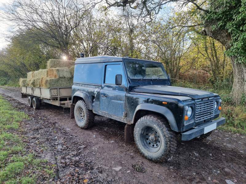 Electrogenic agricultural Land Rover towing straw
